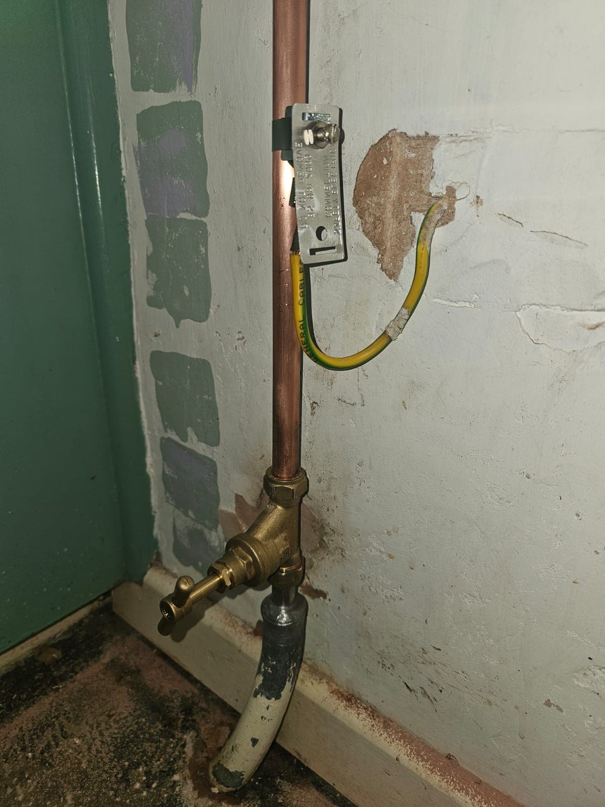 Stop tap, copper pipework and earth bonding detail on an older internal pipe run